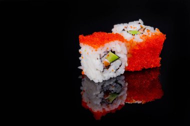Suşi rulosu siyah arkaplanda yansımayla izole edildi.