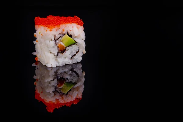 Ρολό σούσι απομονωμένο σε μαύρο φόντο με αντανάκλαση. — Φωτογραφία Αρχείου