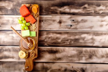 Peynir, üzüm, Kuru Kayısı, fındık ve koyu ahşap arka plan kopya alanı ile ahşap bir gemide incir türleri.