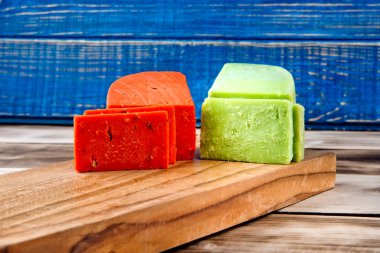 İki tür peynir: yeşil ve kırmızı ahşap oyun tahtası.