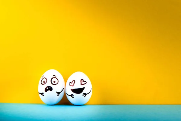 Huevos Pascua Con Diferentes Caras Divertidas Sobre Fondo Azul Amarillo — Foto de Stock