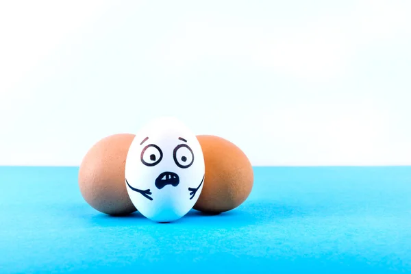 Easter eggs with scared face on blue and white background.