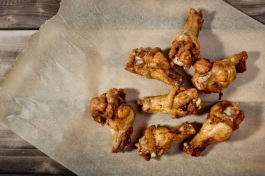 Barbekü tavuk kanadı parşömen kağıt üzerinde.