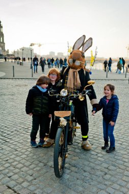 Dresden, Almanya - 02 Nisan 2018: Paskalya tavşanı bir motosiklet üzerinde iletişim kuran turistlerle.
