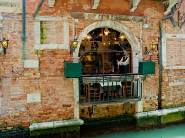 Venice, İtalya - 06 Nisan 2018: Garson kafe pencereden görünüyor.