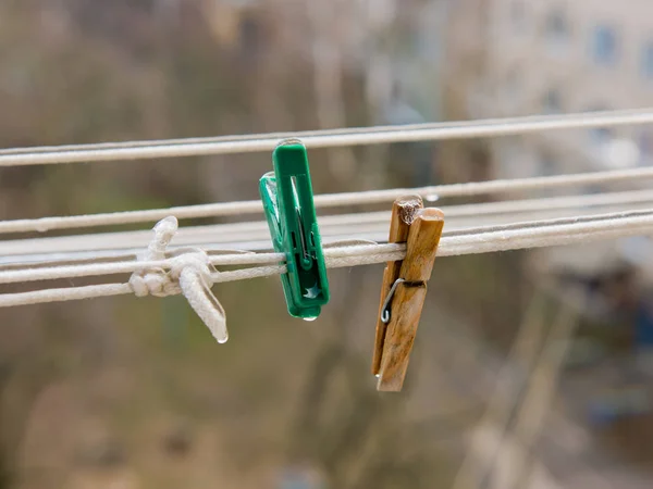 Two clothespins on a clothesline covered with ice.