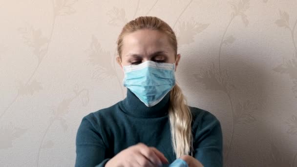 Girl in medical mask puts on blue gloves. — Stock Video