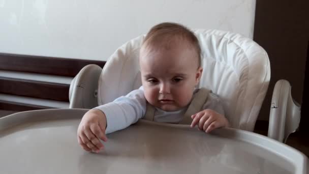 Nahaufnahme Porträt eines kleinen Mädchens, das auf einem Haar für Babys sitzt. — Stockvideo