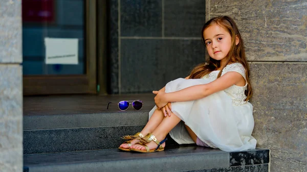 Κοριτσάκι Λευκό Φόρεμα Κάθεται Στα Σκαλιά Και Κοιτάζει Την Κάμερα — Φωτογραφία Αρχείου
