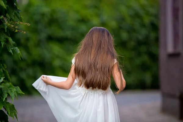 Schattig Meisje Witte Jurk Staat Met Haar Rug Een Groene — Stockfoto