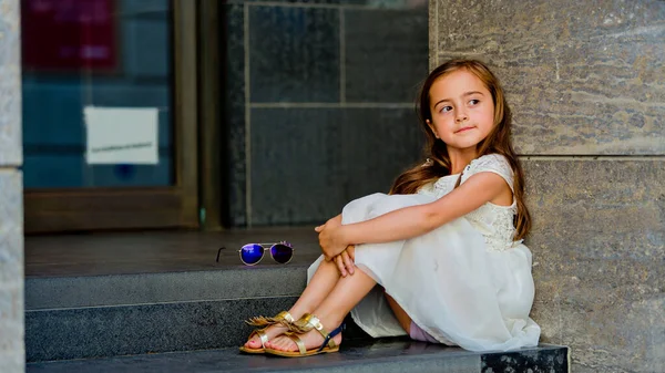 Beyaz Elbiseli Küçük Kız Merdivenlerde Oturuyor Yukarı Bakıyor — Stok fotoğraf