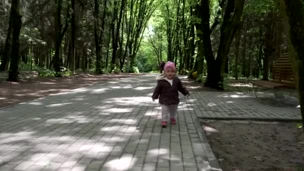 Ein kleines Mädchen rennt im Park in Zeitlupe. — Stockvideo