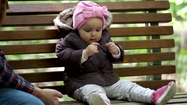 Vater und Tochter sitzen auf einer Parkbank. — Stockvideo