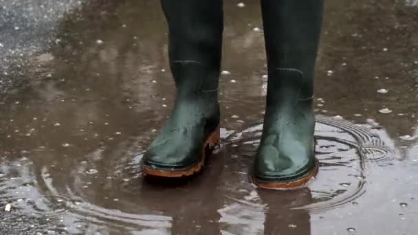 Πράσινες λαστιχένιες μπότες σε λακκούβα. Κοντινό πλάνο. — Αρχείο Βίντεο