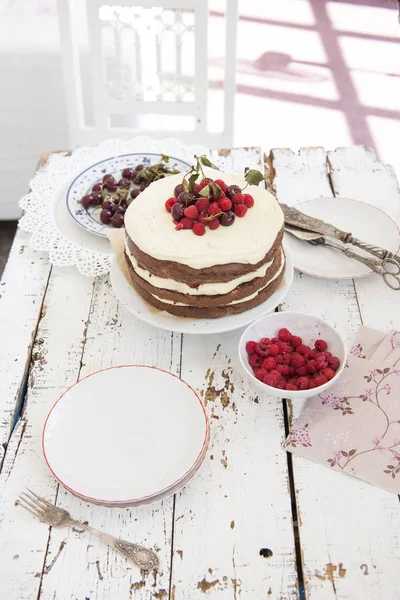 Bolo de esponja de cacau com creme de chicote e framboesas, cerejas — Fotografia de Stock