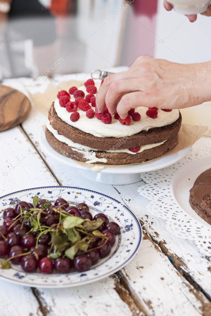 Cocoa Sponge Cake with Whipped Cream and Raspberries, cherries 