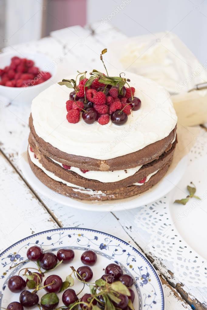 Cocoa Sponge Cake with Whipped Cream and Raspberries, cherries,