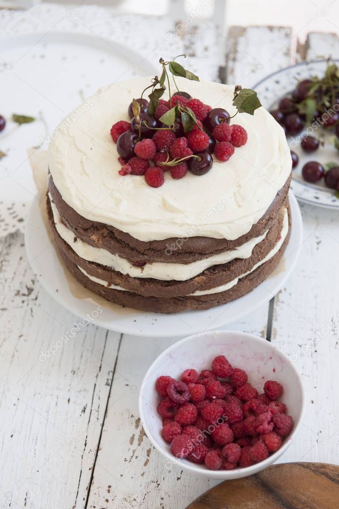 Cocoa Sponge Cake with Whipped Cream and Raspberries, cherries 