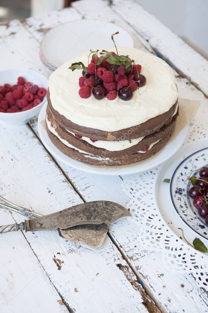 Cocoa Sponge Cake with Whipped Cream and Raspberries, cherries 