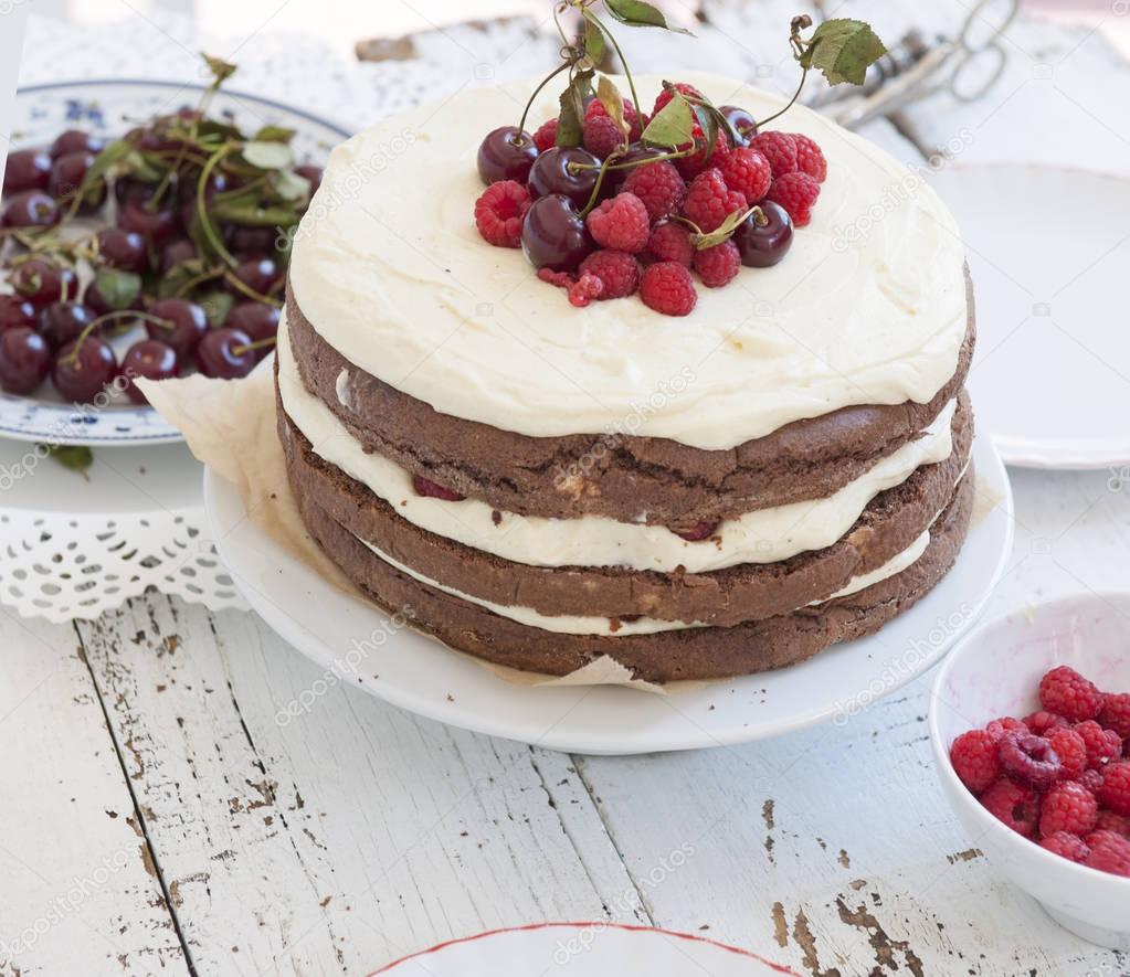 Cocoa Sponge Cake with Whipped Cream and Raspberries, cherries 