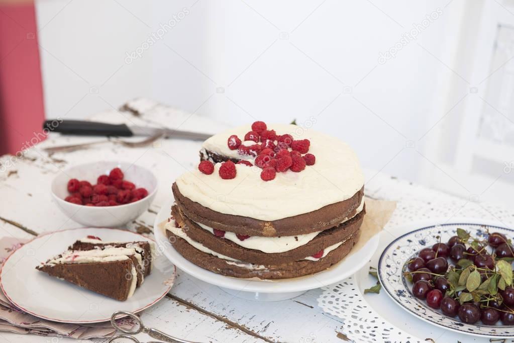 Cocoa Sponge Cake with Whipped Cream and Raspberries, cherries -