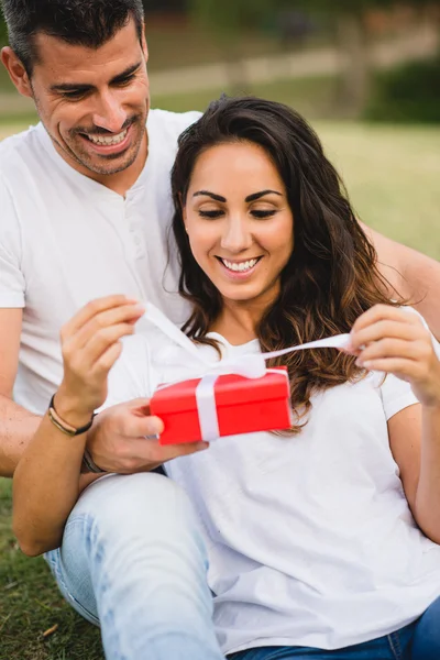 Чоловік дарує подарунок своїй дівчині на святкування річниці — стокове фото