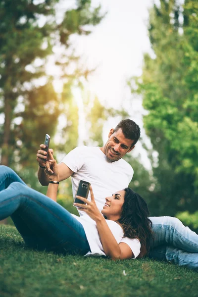 Couple enjoying the outdoors with their mobile phones — Φωτογραφία Αρχείου