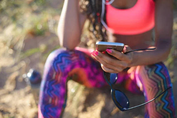 Mulher desportiva usando smartphone — Fotografia de Stock