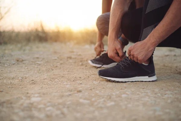 Couple of athletes getting ready for running at sunset — Stock Photo, Image