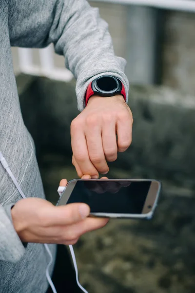 Löpare med sportig smartklocka och smartphone för träning — Stockfoto