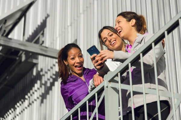Ομάδα σπορ γυναικών διασκεδάζοντας ψάχνει smartphone — Φωτογραφία Αρχείου