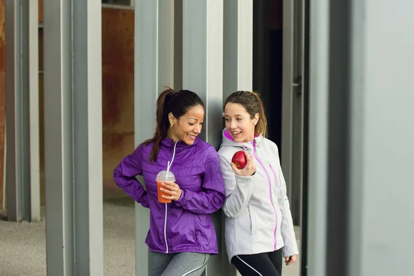 Δύο γυναίκες απολαμβάνοντας σνακ υγιή γυμναστήριο — Φωτογραφία Αρχείου