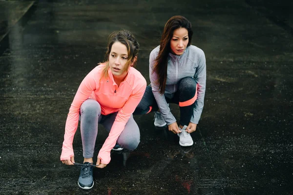 Mujeres listas para correr y entrenar bajo la lluvia — Foto de Stock