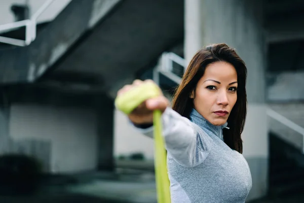 Mujer fuerte haciendo hombro plantea ejercicio con banda de resistencia —  Fotos de Stock