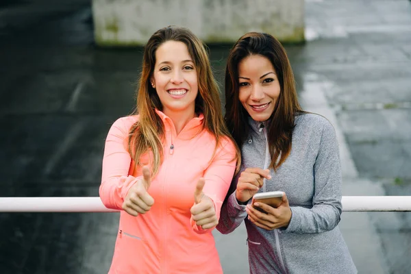 Las mujeres de fitness con éxito con teléfono inteligente — Foto de Stock