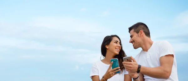 Pareja joven citas y el uso de teléfonos inteligentes juntos —  Fotos de Stock