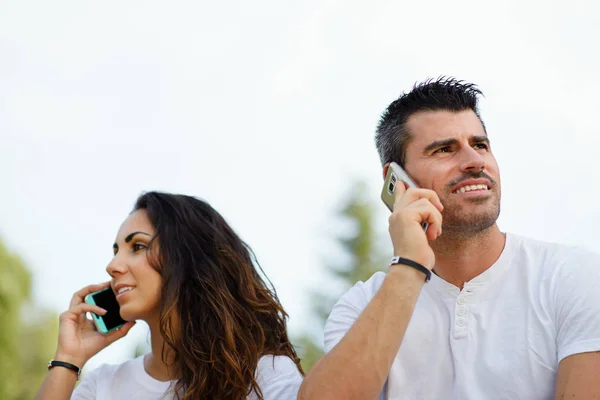 Man and woman on talking on cellphones — Stock Photo, Image