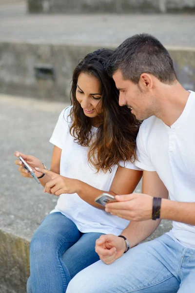 Νεαρό ζευγάρι χρονολόγηση και χρησιμοποιώντας τα smartphones μαζί — Φωτογραφία Αρχείου