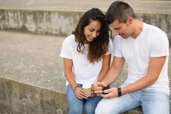 Pareja joven citas y el uso de teléfonos inteligentes juntos — Foto de Stock