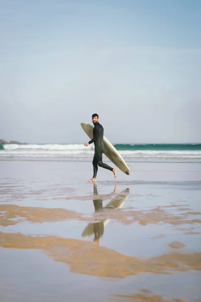 Onun surfboard ile plajda çalışan sörfçü — Stok fotoğraf