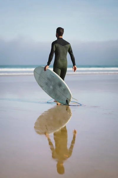 Mann im Neoprenanzug geht zum Surfen aufs Meer — Stockfoto