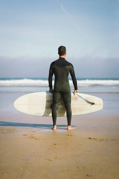 바다를 향해 그의 서핑 보드를 들고 서퍼 — 스톡 사진
