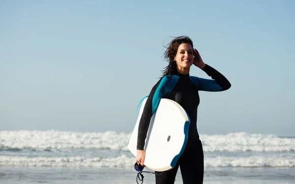 Frau verlässt mit Bodyboard nach dem Surfen das Meer — Stockfoto