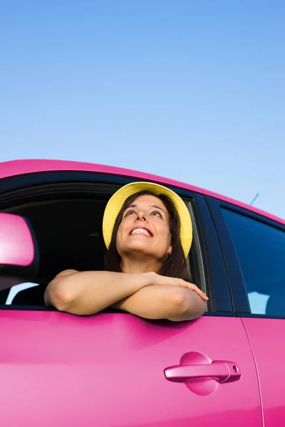 Женщина наслаждается свободой со своей розовой машиной — стоковое фото