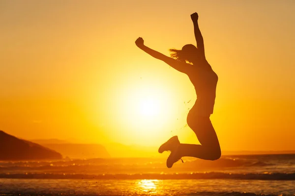 Mulher feliz pulando e se divertindo na praia — Fotografia de Stock