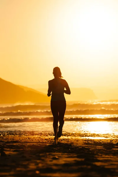 Plajda yaz günbatımı üzerinde çalışan kadın — Stok fotoğraf