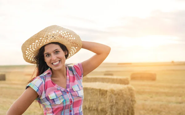 Rural young farmer in harvested wheat field — Stock Photo, Image