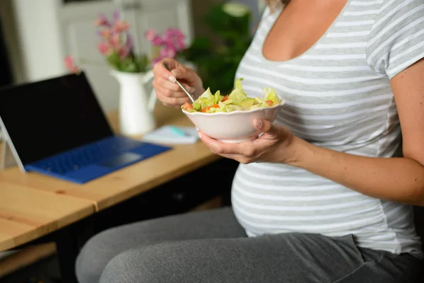 Gravid kvinna äta en hälsosam sallad hemma — Stockfoto