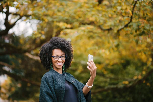 Elegante mujer negra tomando selfie con smartphone en otoño — Foto de Stock