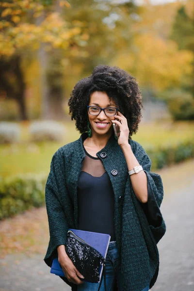 Felice donna nera durante una telefonata cellulare in autunno — Foto Stock